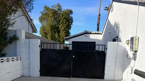 A gated driveway leading to a building with a garage.