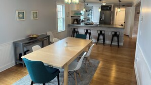 Een moderne keuken met een centraal eiland, barstoelen en hangende lampen.
