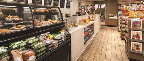 A bakery counter with various baked goods and a deli section with packaged salads and sandwiches.