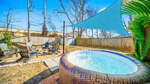 A backyard with a hot tub, lounge chairs, and a shaded area. - Hot Tub/Gameroom/Firepit/ Coler MTB - Downtown (Bentonville)
