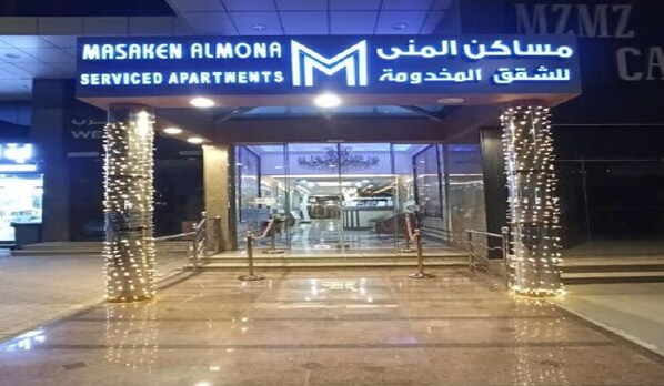 L’entrée des appartements de la résidence Masaken Almona se distingue par sa façade en verre et ses éclairages décoratifs.