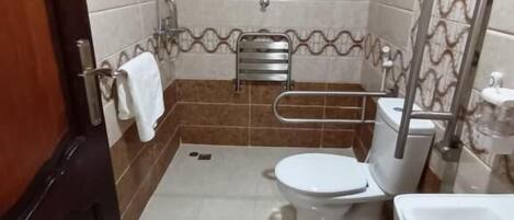 Et badeværelse med toilet, bidet og vask.