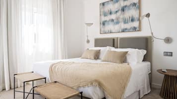 A modern bedroom with a large bed, two bedside tables, a bedside lamp, and a painting on the wall.