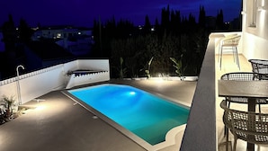 Una piscina con vista a la ciudad al atardecer.