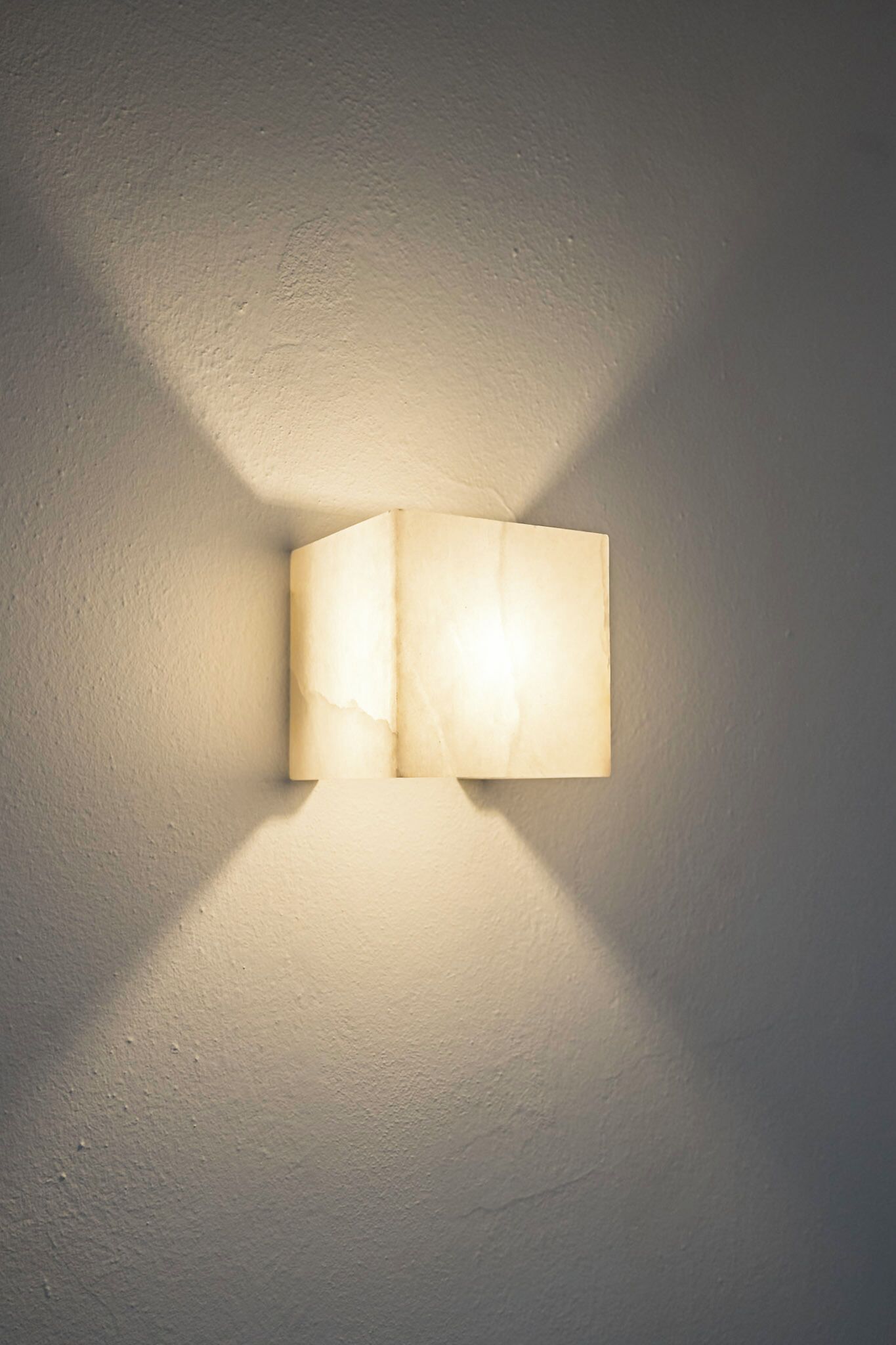 Una lámpara de pared con forma rectangular y fuente de luz visible.