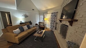 Un salon avec un canapé, une table basse et une cheminée.