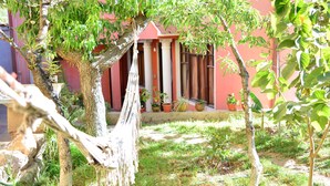A courtyard with a hammock, a tree, and a building with columns and potted plants. - Apartment in residential area (Sucre)