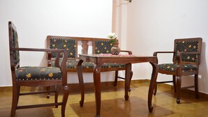 A dining area with a wooden table and two upholstered chairs with floral patterns. - Apartment in residential area (Sucre)