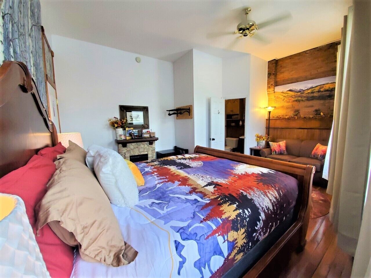 A bedroom with a wooden bed, a nightstand, a dresser, and a painting on the wall.