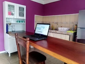 Compact kitchen area with a dining table and storage cabinet, featuring a decorative backsplash.