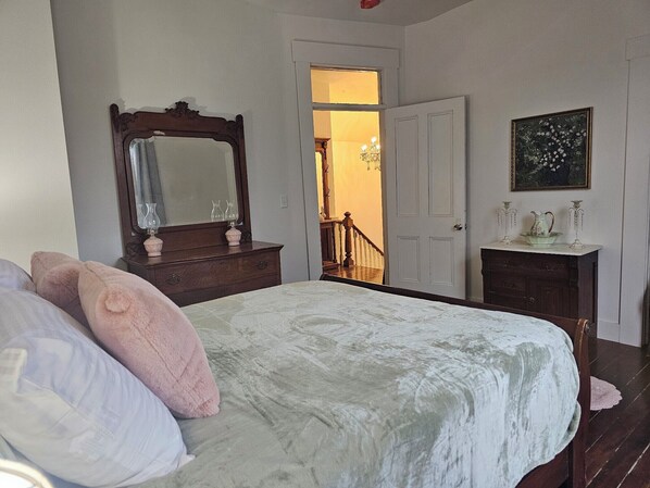 A bedroom with a bed, dresser, and a large mirror. - Hedges House - Upstairs (Independence)