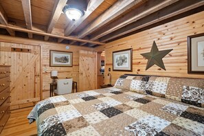 Une pièce de style cabane en bois, avec un lit, une commode et une décoration en forme d’étoile sur le mur.