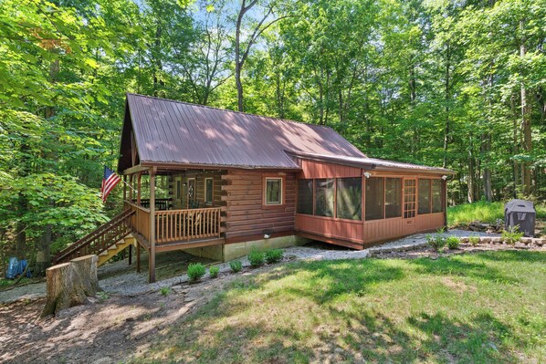 Un chalet rustique doté d’un porche, d’une terrasse et d’un espace extérieur couvert.
