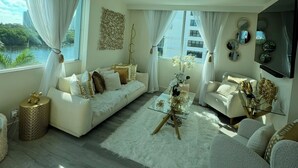A modern living room with a sofa, armchairs, a glass coffee table, and a large window with curtains. - Classy, Eclectic, Congenial hotel suite in charming Fort Lauderdale Florida (Fort Lauderdale)