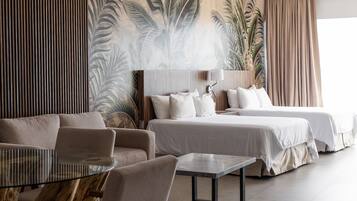 Suite Deluxe, varias camas, balcón, vista a la playa | Caja de seguridad en la habitación y escritorio