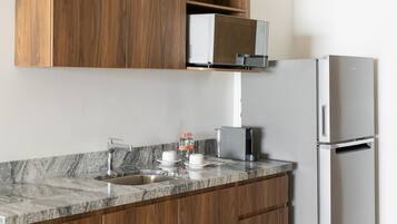 Una cocina moderna con armarios de madera, un refrigerador de acero inoxidable y una encimera de granito.