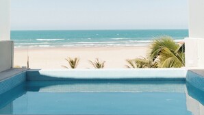 A pool with a view of the beach and ocean.