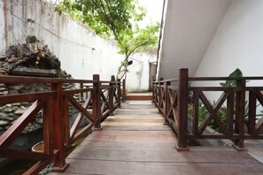 A wooden pathway with railings leading to a building entrance. - We House Guest Hotel (Luang Prabang)