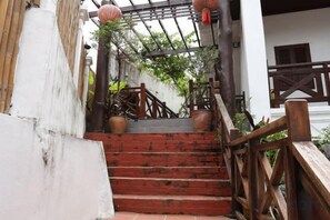 A wooden staircase with a railing, leading to a gated entrance.