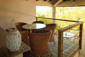 A wooden deck with wicker furniture and a glass table, overlooking a forested area. - Refúgios do Rio Dão - Comfort and privacy in the heart of the Dão Lafões region. (Viseu)