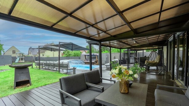 Eine Außenpatio mit Pool, Sitzgelegenheiten und einer Pergola.