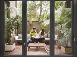A room with a sofa, a table, and potted plants. - Rodamón Barcelona Hostel (Barcelona)