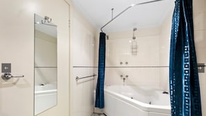 A modern bathroom with a white bathtub, a shower area, and a mirror. - White Crystal 112- ski-in ski-out (Mount Hotham)