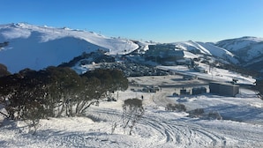 A snow-covered mountain area with a ski resort, including ski lifts and buildings. - White Crystal 112- ski-in ski-out (Mount Hotham)