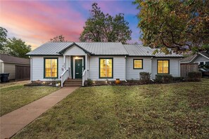Classic home with a symmetrical facade, featuring two windows on each floor and a charming front porch.