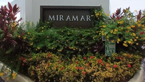 A building with a sign reading "MIRAMAR" surrounded by colorful flowers and greenery. - Azalia Palms: New Oceanview Villa, 15 Min from MBJ Airport (St. James Parish)