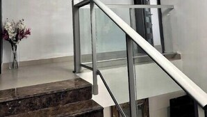 A modern staircase with glass railings and a circular light fixture above. - Azalia Palms: New Oceanview Villa, 15 Min from MBJ Airport (St. James Parish)