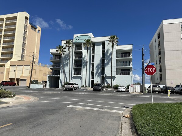 A modern building with balconies and a stop sign at the intersection.
