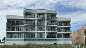 Un hotel de varios pisos con balcones, ventanas amplias y una fachada decorativa.