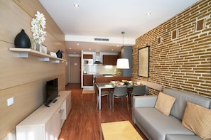 A modern living room with a fireplace, a dining area, and a kitchen in the background. - Serennia Cest Apartamentos Arc De Triomf (Barcelona)