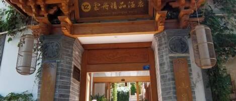 A traditional wooden entrance with a sign indicating a hotel.