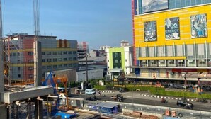 Un edificio de varios pisos con fachada amarilla, ventanas grandes y varios anuncios.
