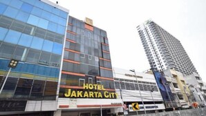 Un hotel con fachada moderna, ventanas amplias y un letrero destacado que dice "HOTEL JAKARTA CITY".