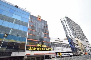 Ein Hotelgebäude mit einem Schild, auf dem 'HOTEL JAKARTA CITY' steht.