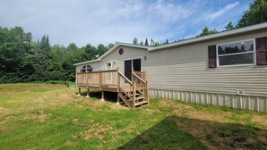 A single-story mobile home with a wooden deck and a small porch. - Trails and fishing paradise  (Nashwauk)