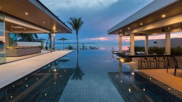 A modern infinity pool with a view of the ocean at dusk. - Exclusive Sea Renity A Beachfront Villa Retreat Sleeps 12 Adults and 6 Kids (Koh Samui)