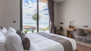 A bedroom with a large bed, a desk, and a view of the ocean. - Exclusive Sea Renity A Beachfront Villa Retreat Sleeps 12 Adults and 6 Kids (Koh Samui)