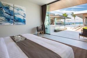 A modern hotel room with a large bed, a view of the ocean, and a balcony with outdoor seating. - Exclusive Sea Renity A Beachfront Villa Retreat Sleeps 12 Adults and 6 Kids (Koh Samui)