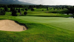 A golf course with a sand bunker, water hazards, and a mountainous backdrop. - Regal Vistas 2 BR 2 BA House at Massanutten Resort (Massanutten)