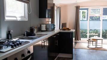 Een moderne keuken met een centraal eiland, inbouwapparatuur en een groot raam met uitzicht op de omgeving.