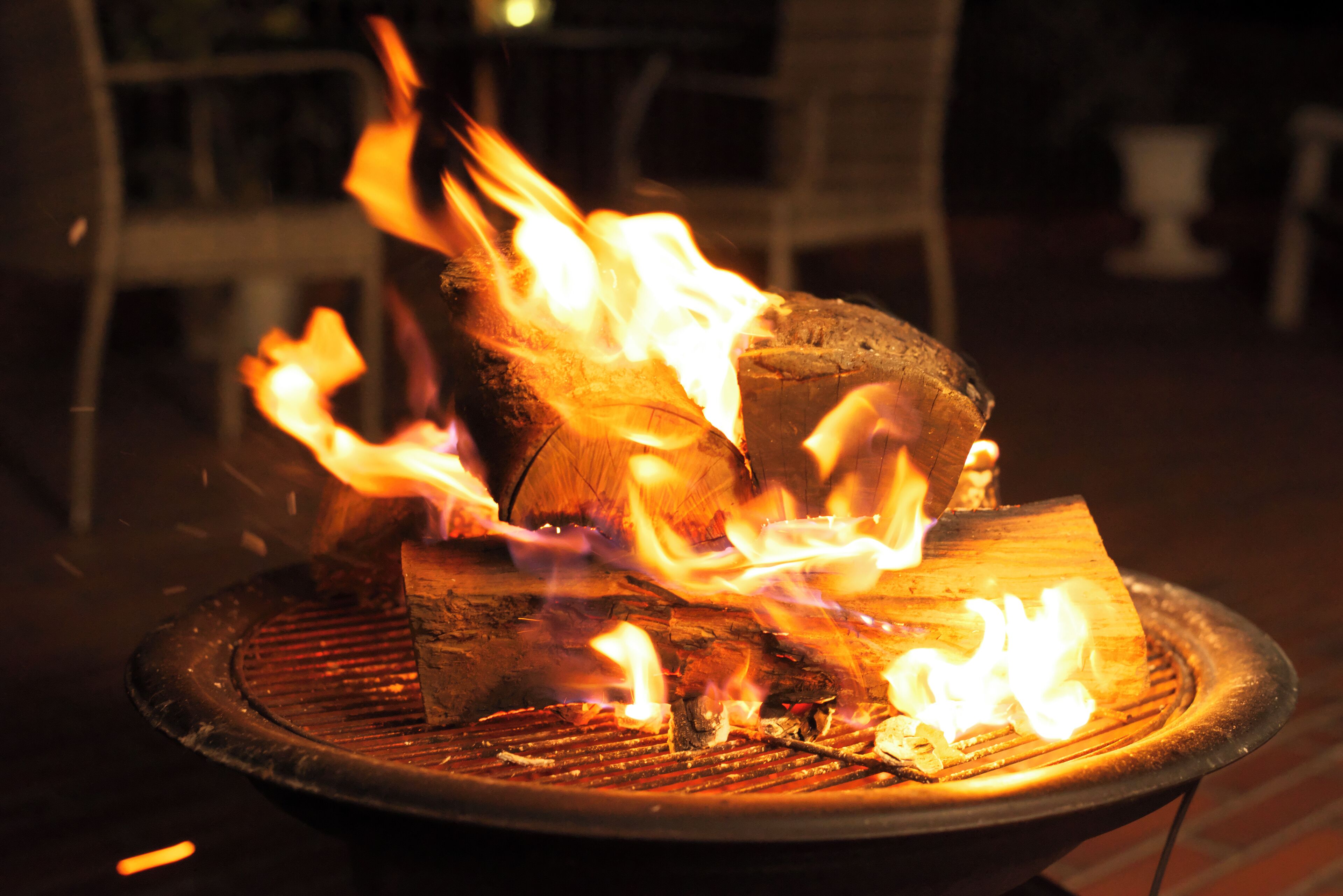 A grill with burning wood and flames.
