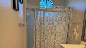 Une salle de bain équipée d’une douche, de toilettes et d’un meuble-lavabo.