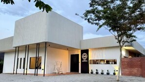 Un edificio moderno con techo plano, una puerta negra y un logo en la fachada.