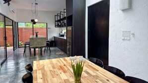 Un comedor moderno con una mesa de madera, sillas y un jarrón con flores.