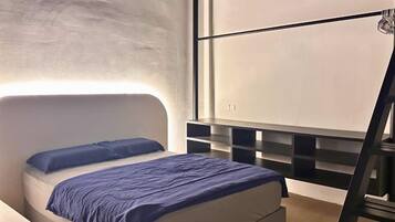 A modern bedroom with a bed, a headboard, a wall-mounted shelf unit, and a ladder.