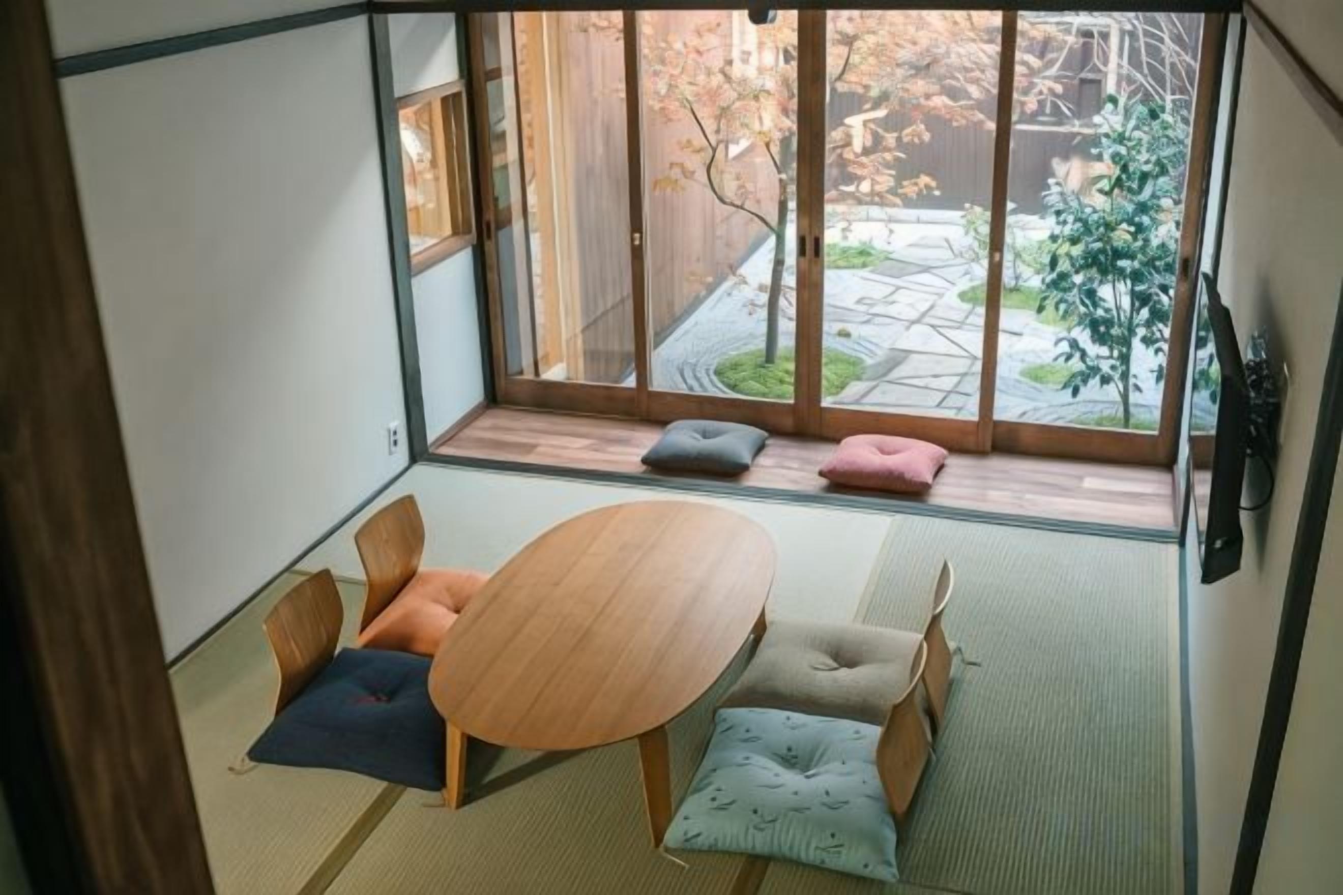 Een traditionele Japanse kamer met tatami vloerbedekking, een lage houten tafel en kussens.